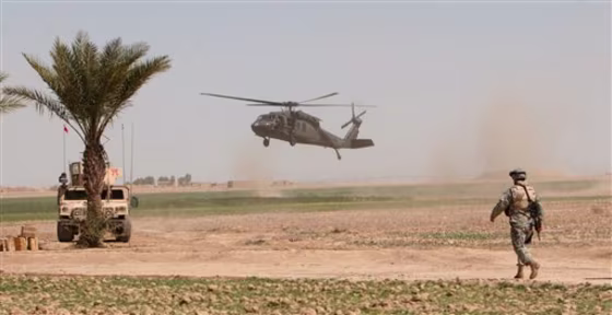 A&nbsp;U.S. helicopter lands in the field in 2006&nbsp;as a U.S. soldier stands guard outside Samarra, Iraq.